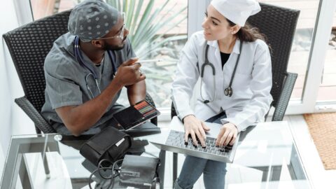 medical professionals sitting on a chair in front of a glass table while having a conversation